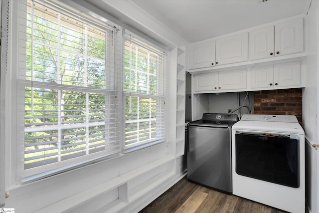 laundry room featuring cabinet space, dark wood finished floors, plenty of natural light, and washing machine and clothes dryer