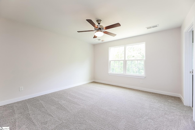 unfurnished room with light colored carpet, ceiling fan, visible vents, and baseboards