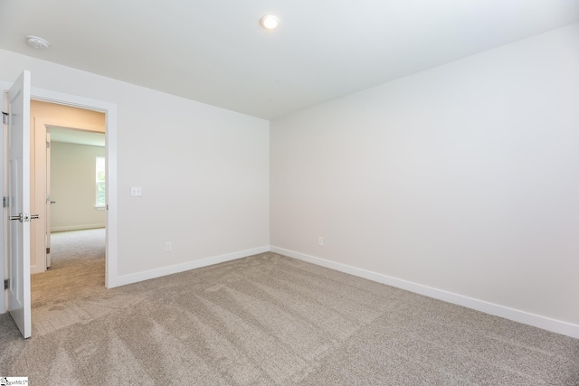 carpeted empty room with baseboards and recessed lighting