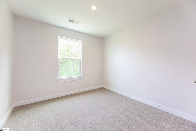 empty room featuring visible vents, baseboards, and carpet floors