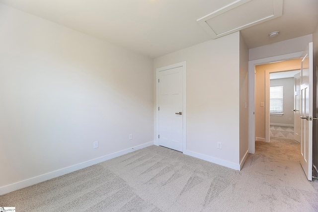 unfurnished bedroom with baseboards, carpet, and attic access