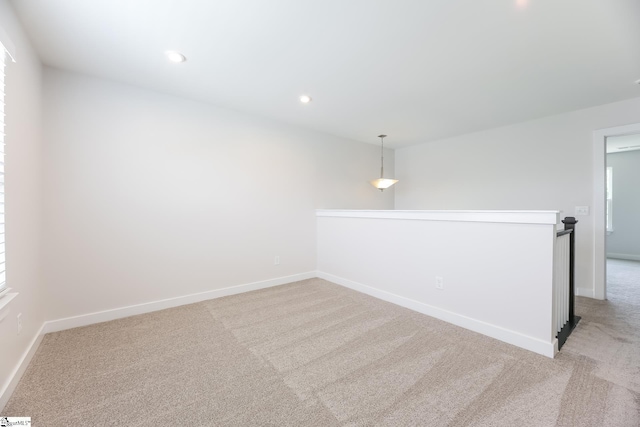 empty room featuring baseboards, recessed lighting, and light colored carpet