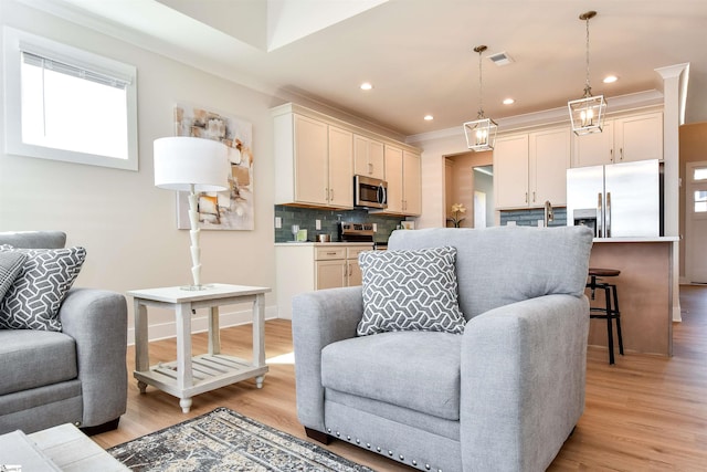 living room featuring crown molding, recessed lighting, light wood-style flooring, and baseboards