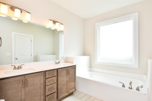 bathroom featuring double vanity, tile patterned floors, a sink, and a garden tub