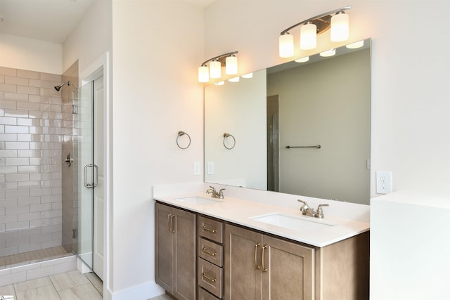 bathroom featuring a sink, a shower stall, and double vanity