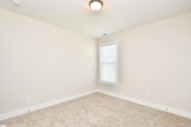 carpeted empty room with baseboards and visible vents