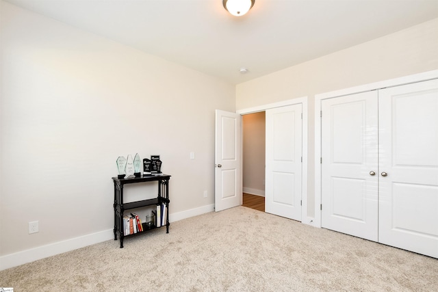 carpeted bedroom featuring baseboards and a closet