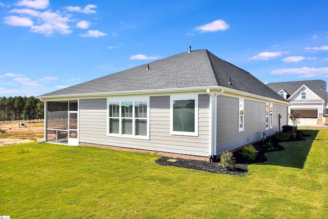 back of property featuring roof with shingles, a sunroom, a yard, and cooling unit