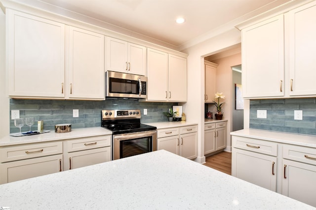 kitchen with crown molding, backsplash, stainless steel appliances, and wood finished floors