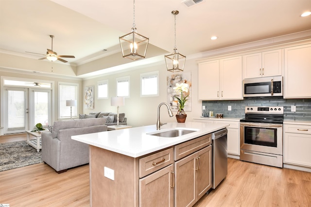 kitchen with light wood-style floors, a sink, appliances with stainless steel finishes, and light countertops