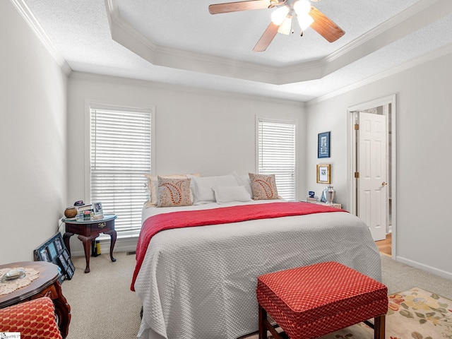 bedroom with a raised ceiling, ornamental molding, a ceiling fan, and light colored carpet