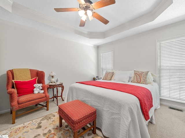 bedroom featuring carpet floors, crown molding, and a tray ceiling