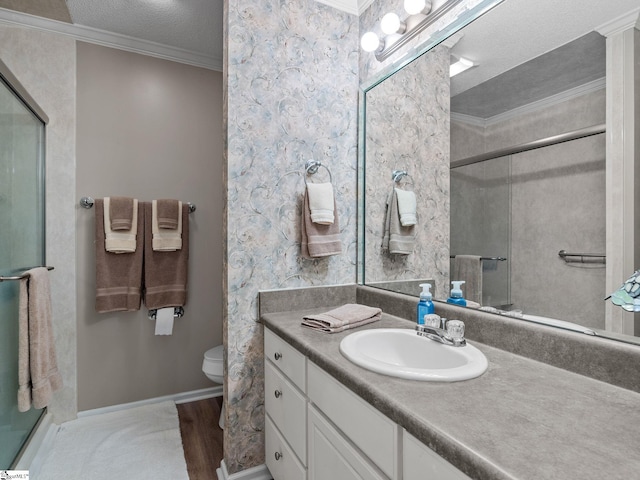 full bathroom with vanity, crown molding, a shower with door, toilet, and a textured ceiling