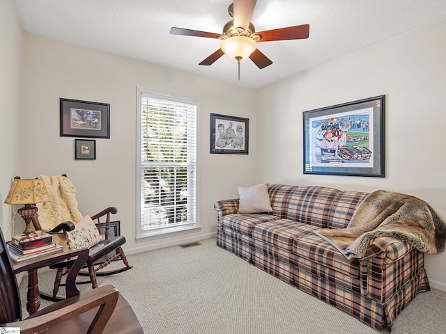 carpeted living room featuring a ceiling fan, baseboards, and visible vents