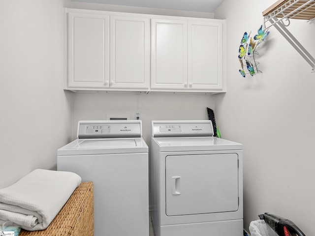 laundry room featuring washing machine and clothes dryer and cabinet space