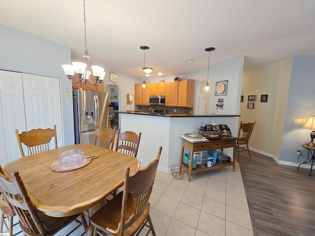 dining room with baseboards, light tile patterned flooring, and a notable chandelier