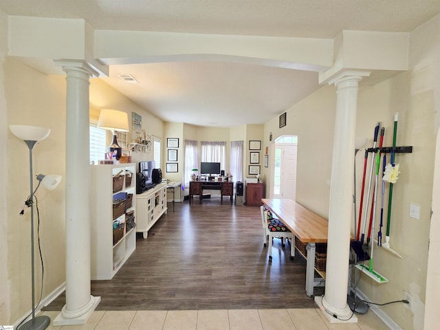 dining room featuring ornate columns, visible vents, and wood finished floors