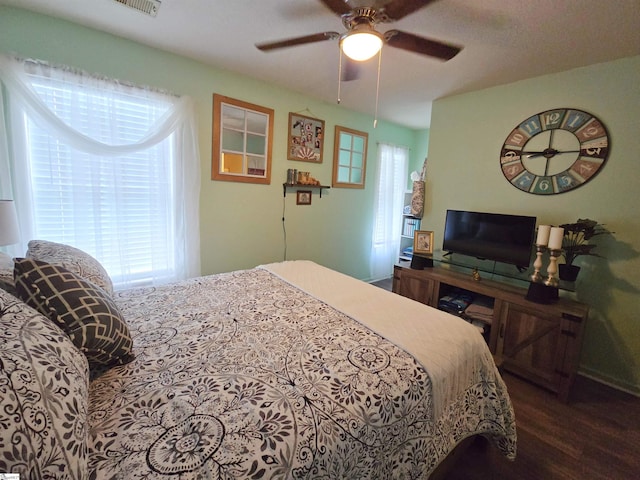 bedroom with a ceiling fan, multiple windows, and wood finished floors