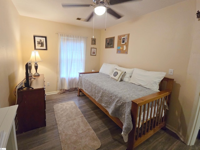 bedroom featuring baseboards, ceiling fan, wood finished floors, and visible vents