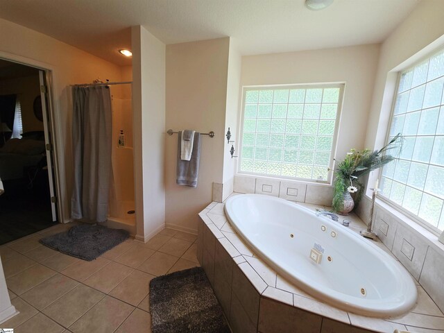 bathroom featuring tile patterned flooring, a stall shower, and a wealth of natural light