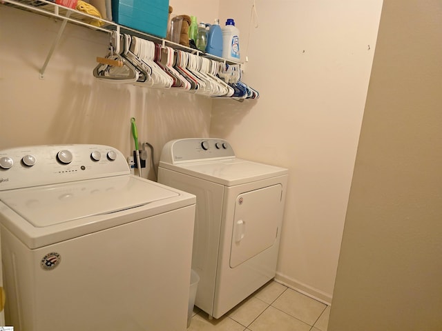 laundry room featuring separate washer and dryer, laundry area, and light tile patterned floors