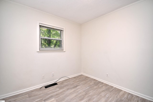 unfurnished room with baseboards, ornamental molding, and wood finished floors