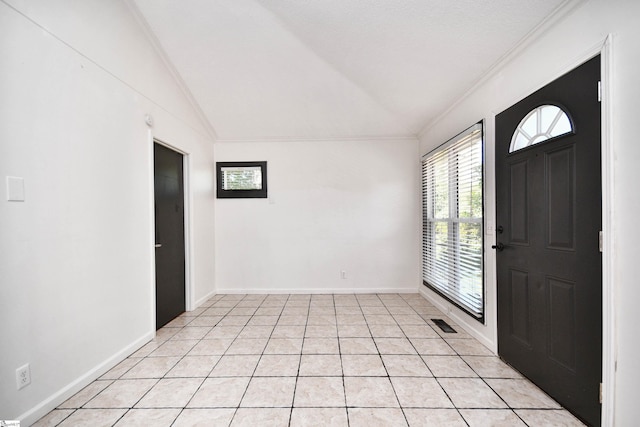 entryway with visible vents, ornamental molding, lofted ceiling, baseboards, and light tile patterned floors