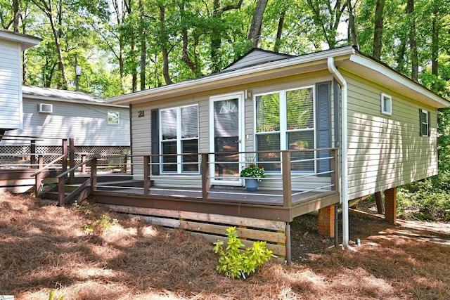 rear view of property featuring a wooden deck