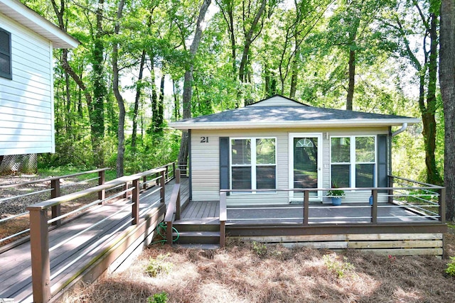 view of property exterior featuring a wooden deck and roof with shingles