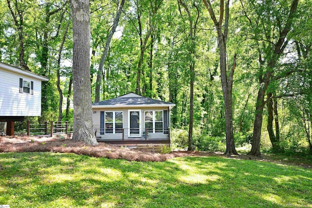 back of property with a lawn and fence