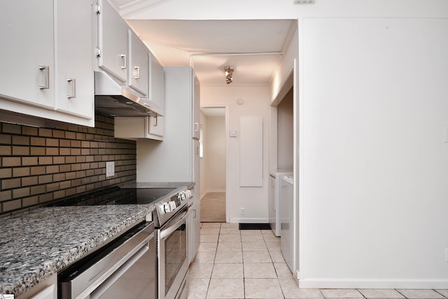 kitchen featuring decorative backsplash, appliances with stainless steel finishes, light tile patterned floors, separate washer and dryer, and under cabinet range hood