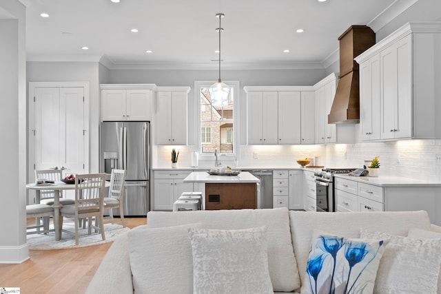 kitchen featuring decorative backsplash, appliances with stainless steel finishes, white cabinets, and ornamental molding