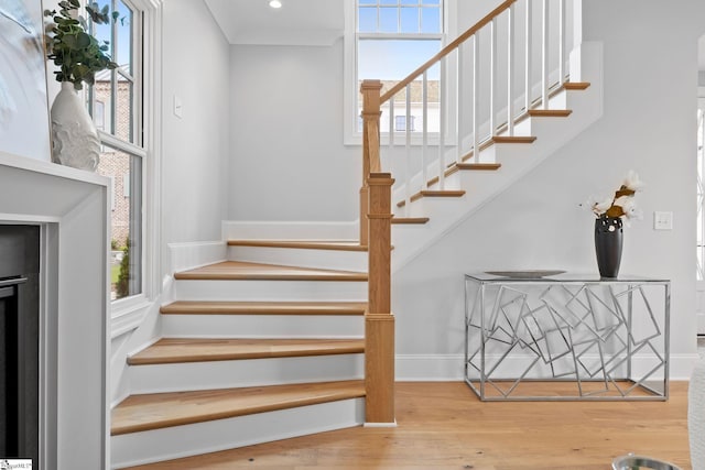 stairs featuring baseboards, recessed lighting, wood finished floors, and a healthy amount of sunlight
