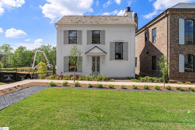 view of front facade featuring a chimney and a front lawn