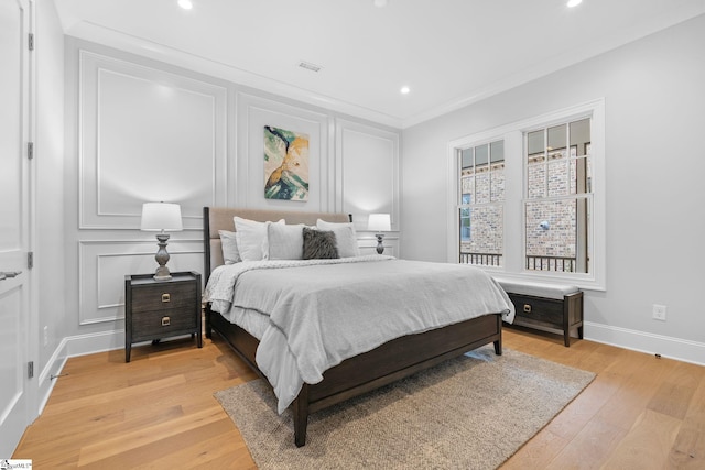 bedroom with visible vents, crown molding, light wood-style floors, baseboards, and recessed lighting