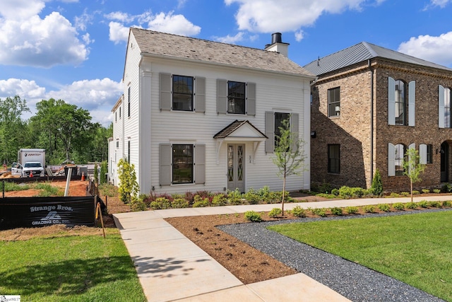 view of front facade with a chimney and a front yard