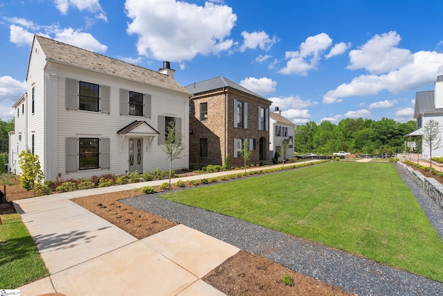view of front of home with a front yard and a chimney