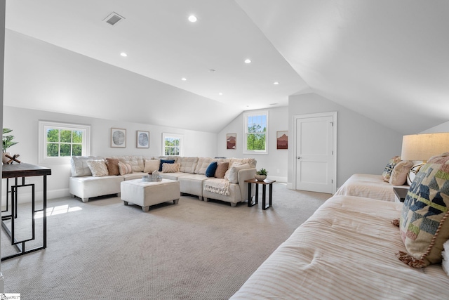 living area with plenty of natural light, visible vents, light colored carpet, and lofted ceiling