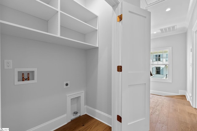 clothes washing area with laundry area, electric dryer hookup, visible vents, wood finished floors, and hookup for a washing machine