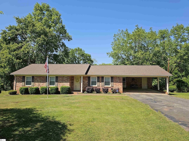 ranch-style house featuring brick siding, driveway, a carport, and a front lawn