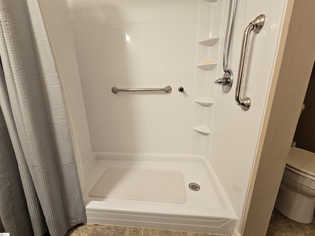 bathroom featuring a shower stall and toilet
