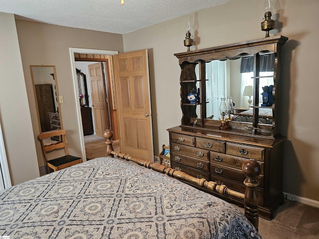 carpeted bedroom with a textured ceiling and baseboards