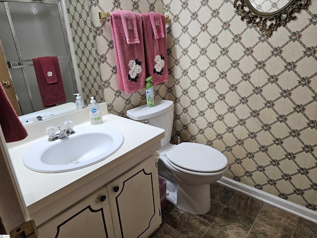 full bath featuring toilet, baseboards, a shower stall, and vanity