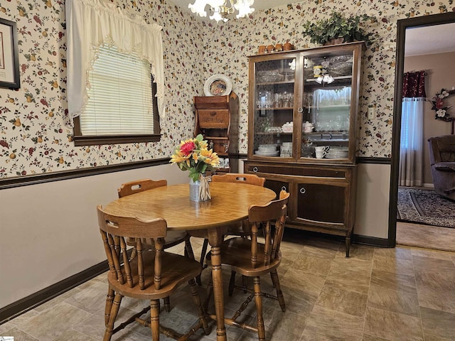 dining area with wallpapered walls, an inviting chandelier, and baseboards