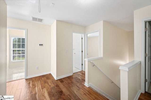 interior space with baseboards, wood finished floors, and visible vents