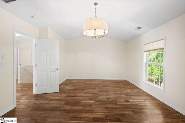 empty room featuring dark wood-style flooring, baseboards, visible vents, and vaulted ceiling