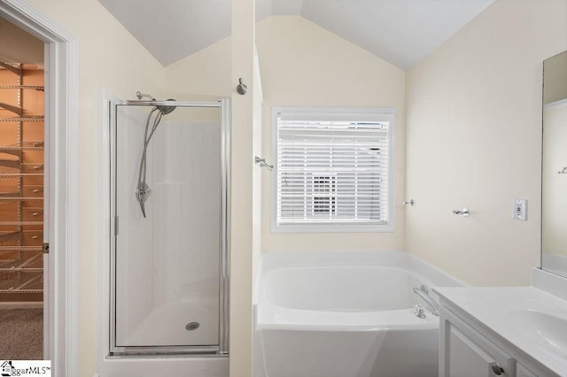 bathroom featuring a garden tub, vanity, lofted ceiling, a spacious closet, and a shower stall