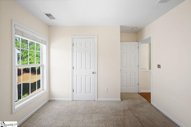 unfurnished bedroom with baseboards, carpet flooring, and visible vents