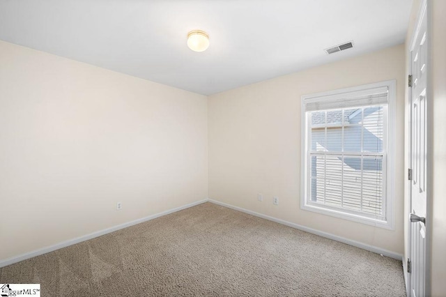 carpeted empty room featuring baseboards and visible vents