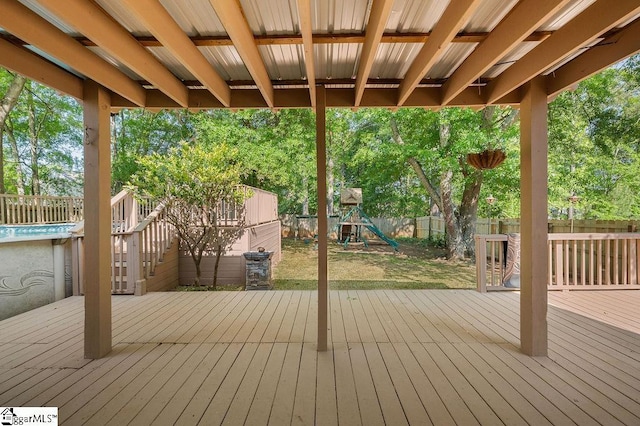 deck featuring a fenced backyard and a playground